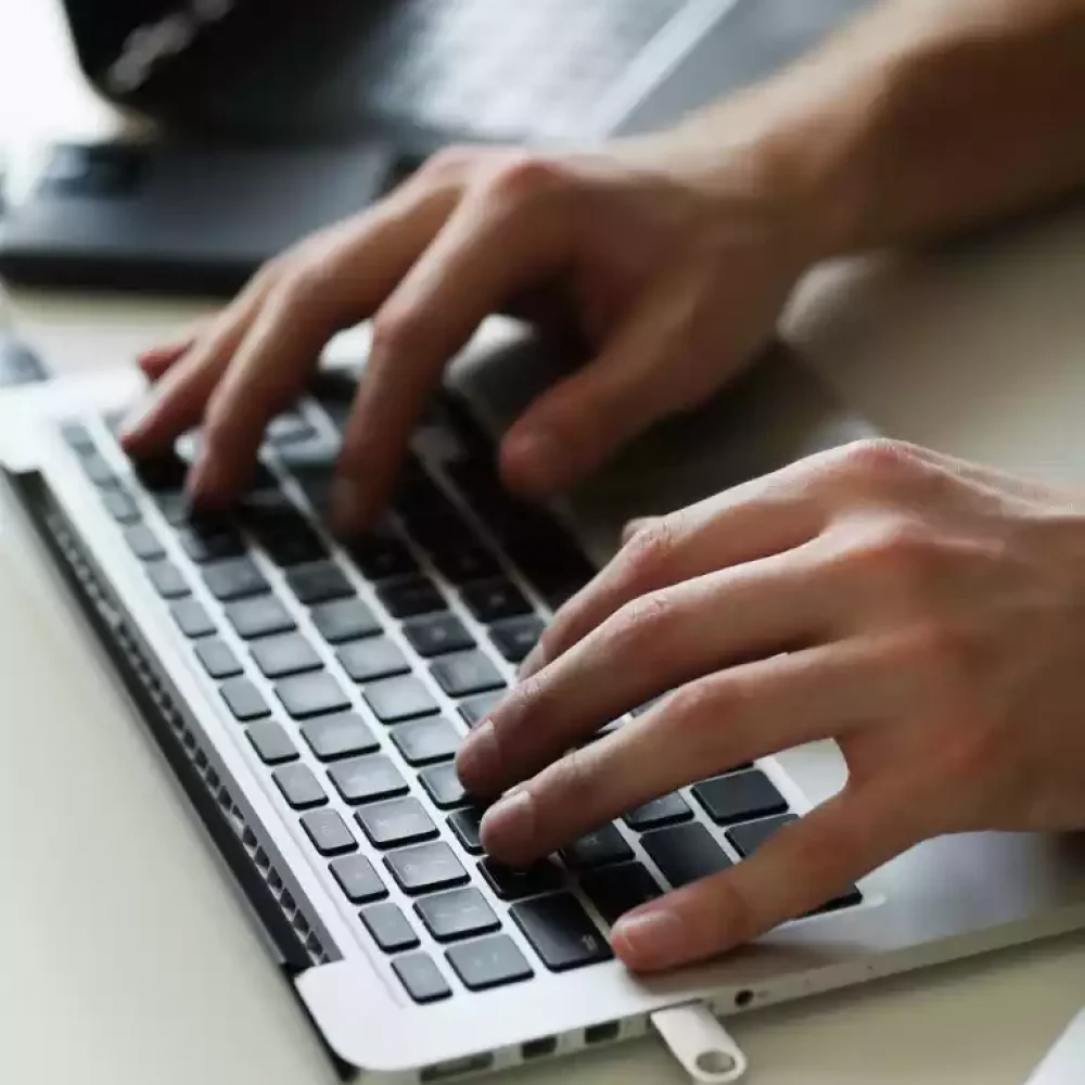 Développeur web qui tape sur un clavier d'ordinateur portable.